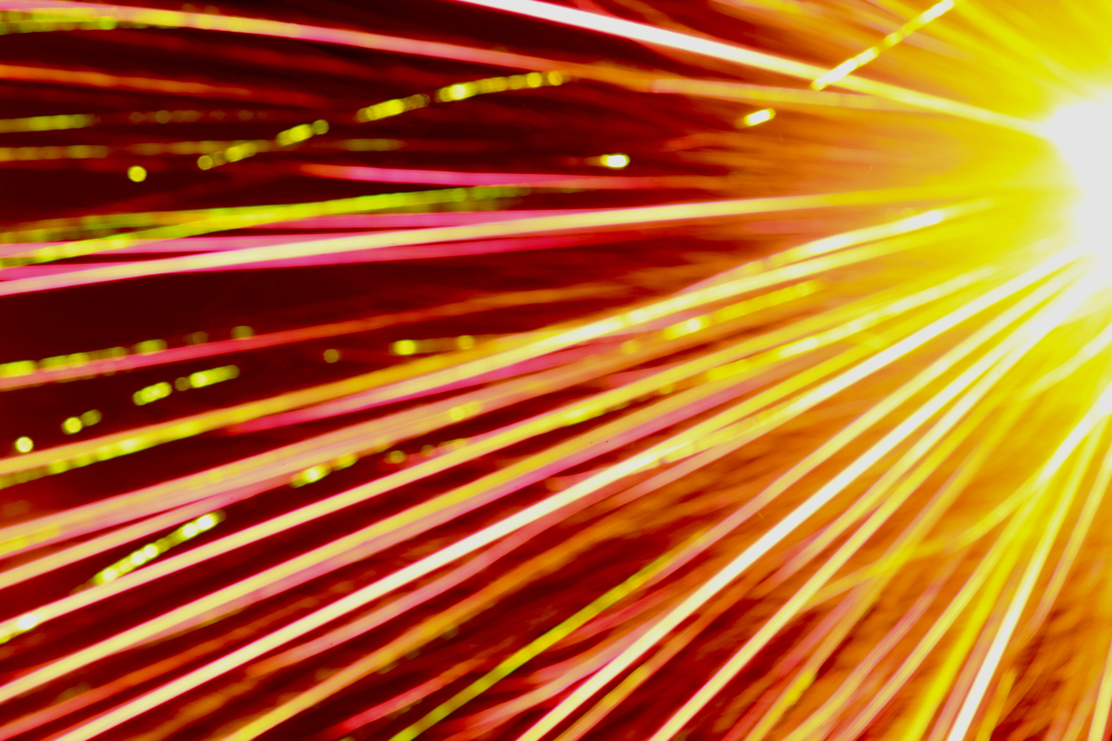 Abstract warm light streaks radiating outward in red and gold