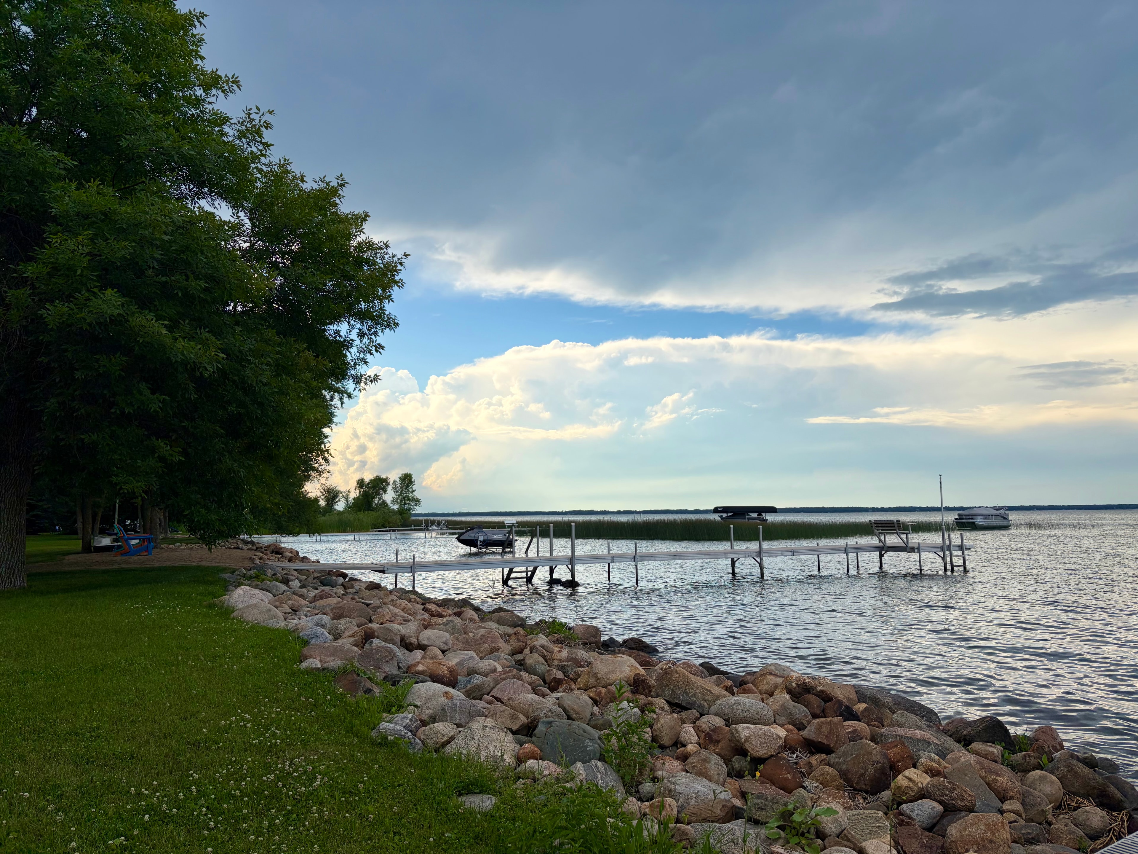 Lakeside dock and storm clouds building over calm water